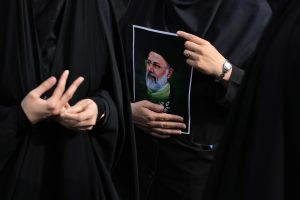 An Iranian woman holds a poster of President Ebrahim Raisi during a mourning ceremony in Tehran, Iran. (AP)