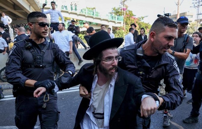 Police detain an ultra-Orthodox Jewish man during a protest against a Supreme Court order for ultra-Orthodox men to begin enlisting for military service, on June 27, 2024. (AFP)