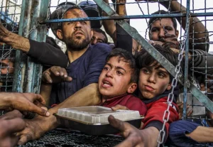 Children from Palestine receive food assistance at a Gaza refugee camp