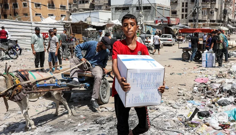 In the heart of Gaza City, a youngster holds a parcel of humanitarian goods from the United Nations Relief and Works Agency for Palestine Refugees (UNRWA).