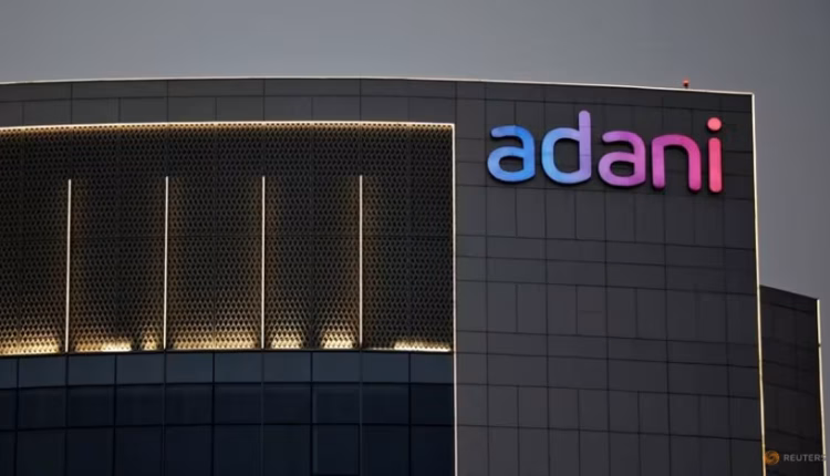 The Adani Group's logo is visible on the facade of a structure located on the outskirts of Ahmedabad, India