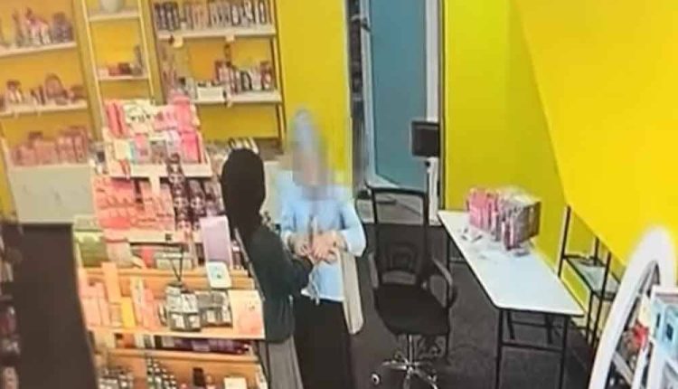 The screenshot shows the suspect (right) approaching the employee (left) involved before taking the victim's jewelry.