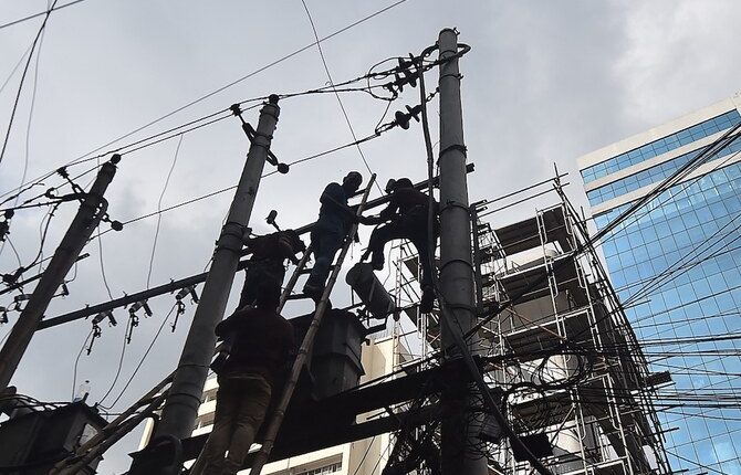 Workers from the Dhaka Electric Supply Company Limited repair an electrical transformer in Dhaka