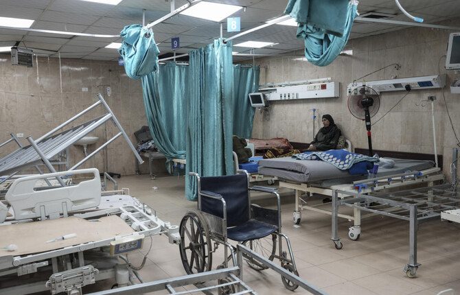 FILE - A woman sits on a bed in a room of the Al-Aqsa Martyrs hospital in Deir al Balah, Gaza Strip
