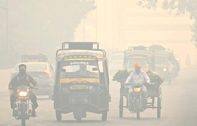 Commuters make their way along a street amid smoggy conditions in Amritsar on November 3, 2024. (AFP)