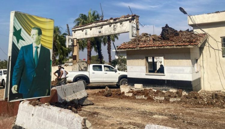 A poster depicting Syria's President Bashar al-Assad is seen at a damaged area in the aftermath of an Israeli strike in Hama