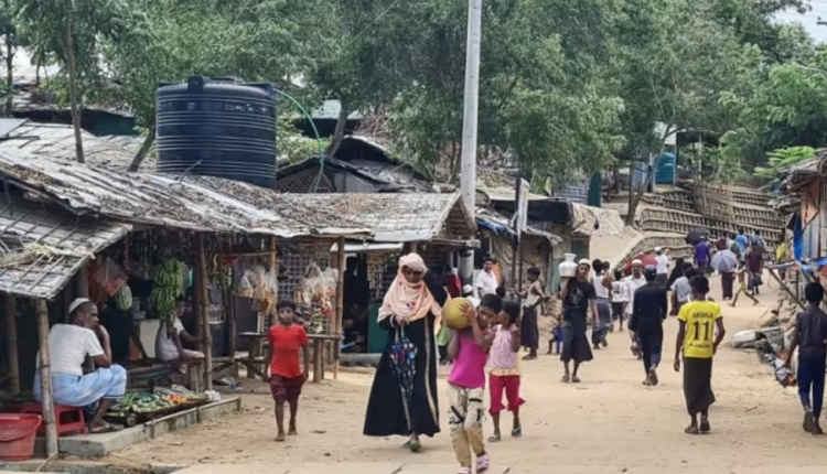 Rohingya refugees walking down a path at a Rohingya refugee camp in Ukhia in Bangladesh's southeastern Cox's Bazar district