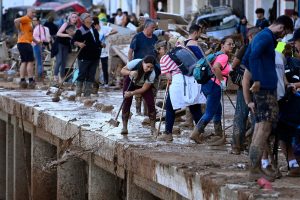 Locals and volunteers remove muddy water on Nov. 1, 2024, after a flooding devastated the town of Paiporta, in the region of Valencia, eastern Spain. (AFP)