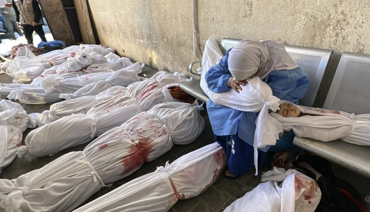 A Palestinian woman reacts over the body of a child as she sits by bodies of Palestinians killed by Israeli airstrikes on Jabaliya refugee camp, at the Indonesian hospital, northern Gaza Strip
