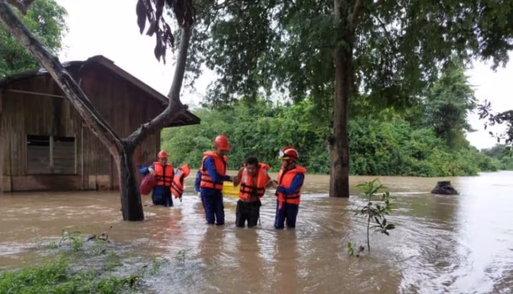 Malaysian rescue workers assist a guy affected by the flood in Pendang, Kedah. (Image: Facebook/Agensi Pengurusan Bencana Negara, Jabatan Perdana Menteri.)