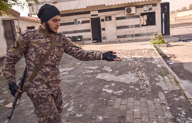 On December 12, 2024, a Syrian opposition fighter discards Captagon tablets at Mazzeh Military Airport west of Damascus.
