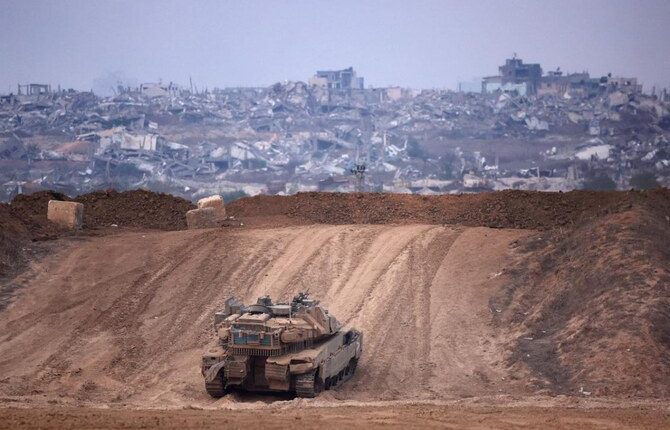 An Israeli army tank drives into position near Israel's southern border with the Gaza Strip on December