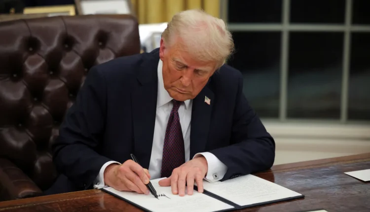 U.S. President Donald Trump signs documents as he issues executive orders and pardons for January 6 defendants in the Oval Office at the White House on Inauguration Day in Washington, U.S., January 20, 2025. Source: REUTERS/Carlos Barria