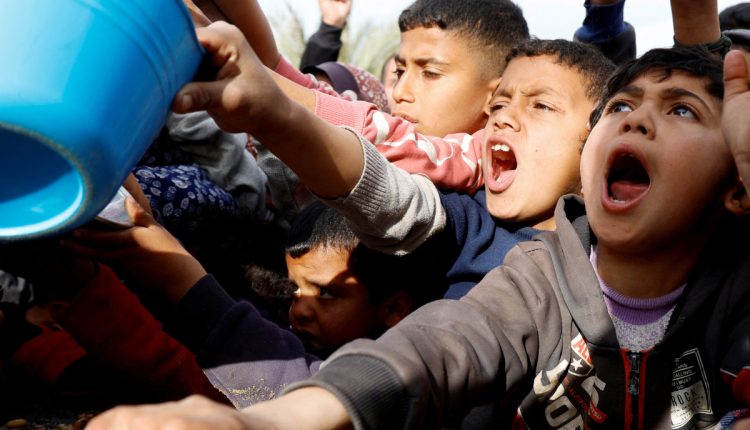 Palestinian children gather to receive food cooked by a charity kitchen, during the Muslim holy month of Ramadan, in Khan Younis, in the southern Gaza Strip, March 3, 2025. (REUTERS)